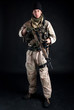 Soldier with rifle against black background.