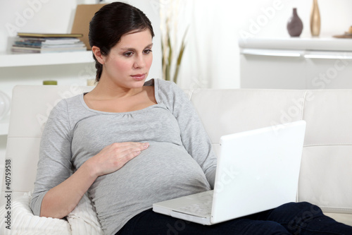Photo: Pregnant brunette browsing the Internet Pregnant brunette browsing the Internet