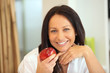 Woman holding apple with bright smile Woman holding apple with bright smile