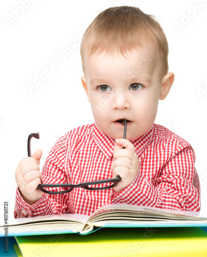 Photo: Little child play with book and glasses Little child play with book and glasses
