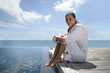 Brunette sat at theend of a jetty