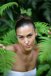 Brunette posing by plant leaves