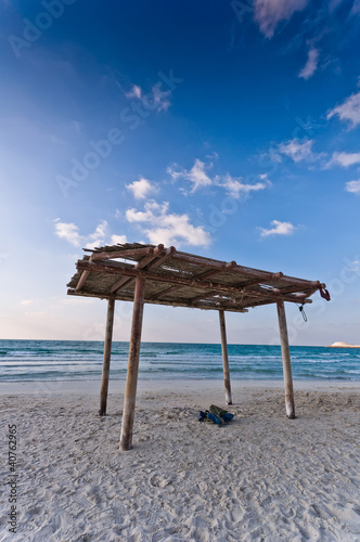 Foto: wooden canopy on the sandy beach and blue sky wooden canopy on the sandy beach and blue sky