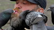 Man feeds pigeons with his mouth