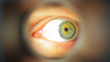 Mans eye looking through a blured hole Mans eye looking through a blured hole