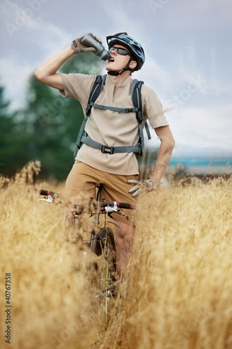 Photo: off road biker drinking isotonic drink and having rest off road biker drinking isotonic drink and having rest