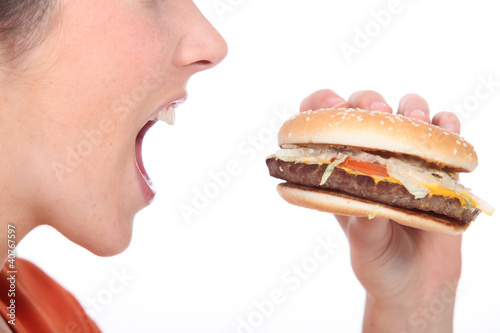 Photo: Woman eating cheeseburger Woman eating cheeseburger