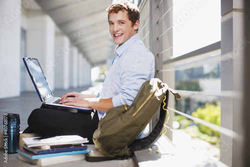 Photo: Student working on laptop on floor Student working on laptop on floor