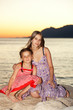 Two girls sitting by the sea