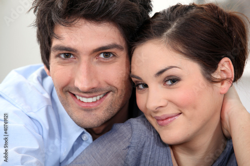 Photo: Couple sat hugging at home Couple sat hugging at home
