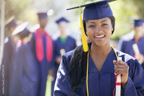 Foto: Smiling graduate holding diploma Smiling graduate holding diploma