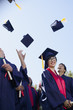 Graduates tossing caps in air outdoors