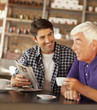 Men reading newspaper in cafe