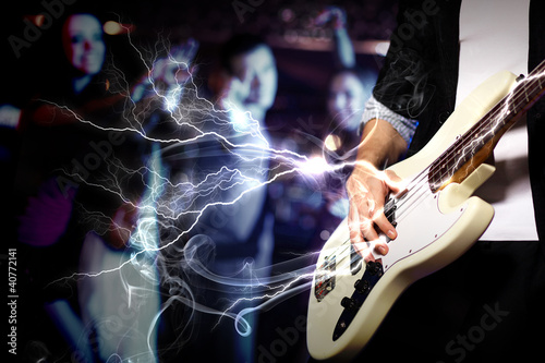 Illustration: Young guitar player performing in night club Young guitar player performing in night club