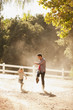 Father and son kicking up dust on dirt road