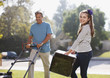 Father and daughter mowing lawn together