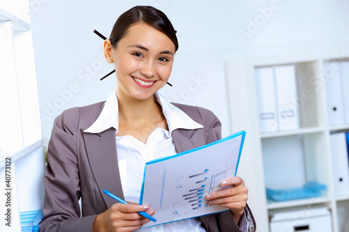 Photo: Young woman in business wear working in office Young woman in business wear working in office