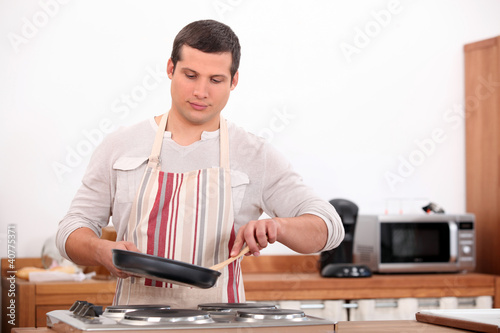 Photo: Boy with a pan in the kitchen Boy with a pan in the kitchen