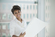 Businesswoman reading blueprints in office