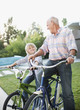 Older man and grandson riding bicycles outdoors