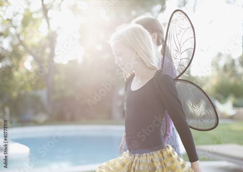 Photo: Girl wearing fairy wings in backyard Girl wearing fairy wings in backyard