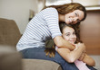 Mother and daughter hugging indoors