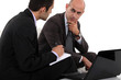 Two businessmen discussing project Two businessmen discussing project