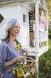 Older woman picking flowers outdoors