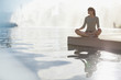 Woman meditating by still pool