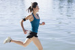 Woman running along lake