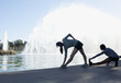 Runners stretching by fountain in lake