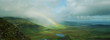 Rainbow stretching over rural landscape