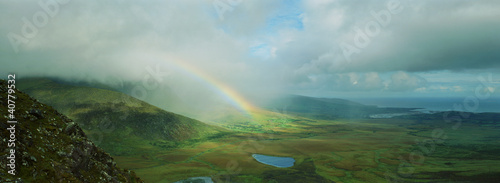 Photo: Rainbow stretching over rural landscape Rainbow stretching over rural landscape