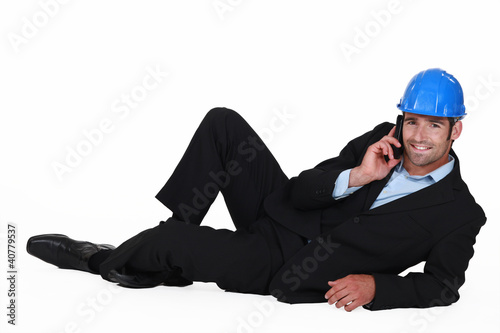 Foto: Architect laying on floor making telephone call Architect laying on floor making telephone call