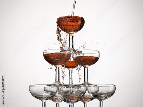 Photo: Champagne pouring into stacked glasses Champagne pouring into stacked glasses