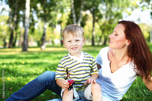 Photo: Young mother with her son in summer park Young mother with her son in summer park