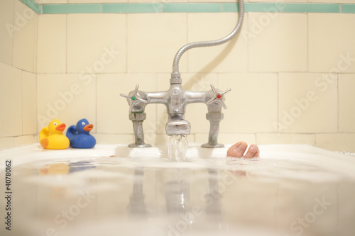 Photo: Faucet pouring water into bath tub Faucet pouring water into bath tub