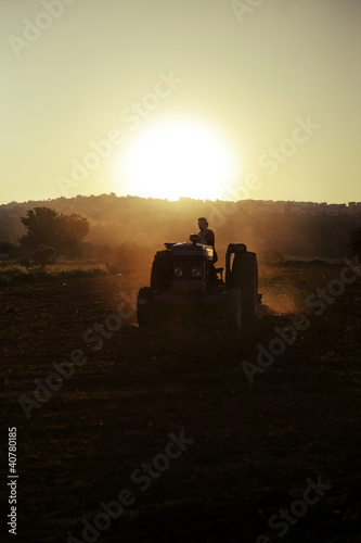 Photo: Farmer driving tractor in crop fields Farmer driving tractor in crop fields