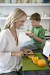 Mother slicing oranges for son