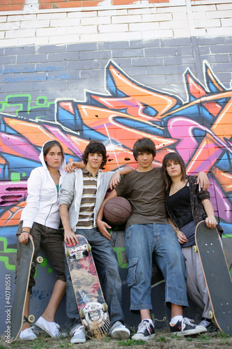 Photo: teenagers posing in front of tagged wall teenagers posing in front of tagged wall