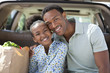 Father and daughter unloading groceries from car