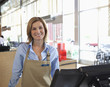 Cashier standing at till in supermarket
