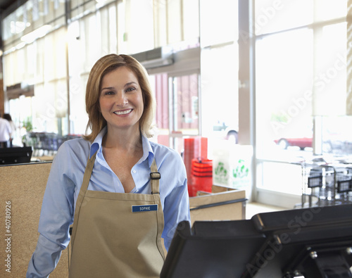 Photo: Cashier standing at till in supermarket Cashier standing at till in supermarket