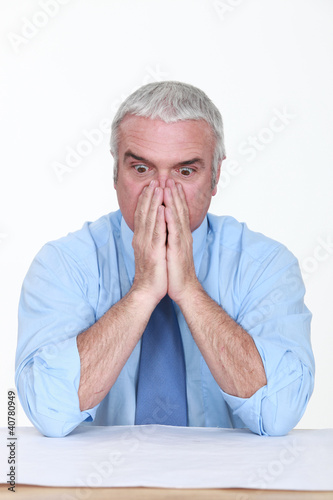 Photo: Appalled man looking at a blueprint Appalled man looking at a blueprint
