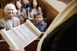 Rabbi reading from Torah scrolls in synagogue