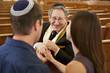 Couple talking with rabbi in synagogue