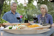 Older couple praying at dinner table