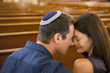 Man in yarmulke praying with girlfriend