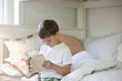 Boy reading Bible on bed