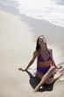 Woman sitting cross-legged on beach